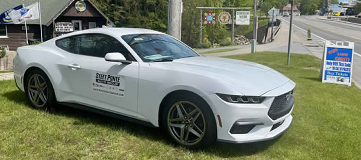 May be an image of car, road and text